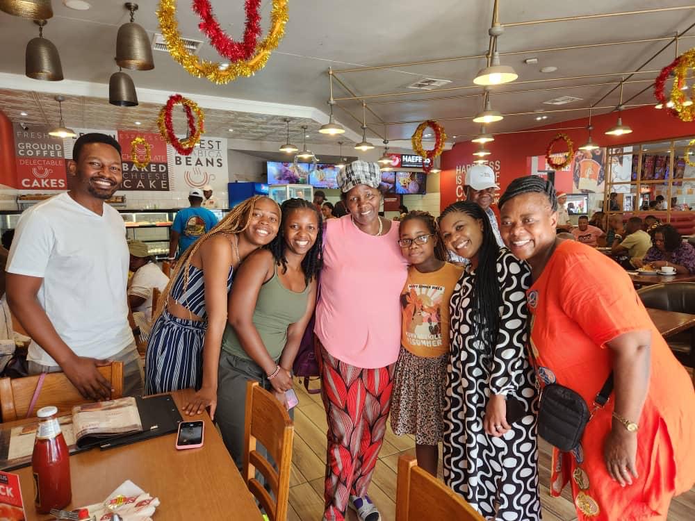 Mama Joy laughing with family and friends at a Nairobi café